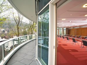 Blick in einen großen Tagungs- und Veranstaltungsraum im Schwarzwald Panorama mit angrenzender Terrasse und Blick auf den Ort und die Landschaft von Bad Herrenalb