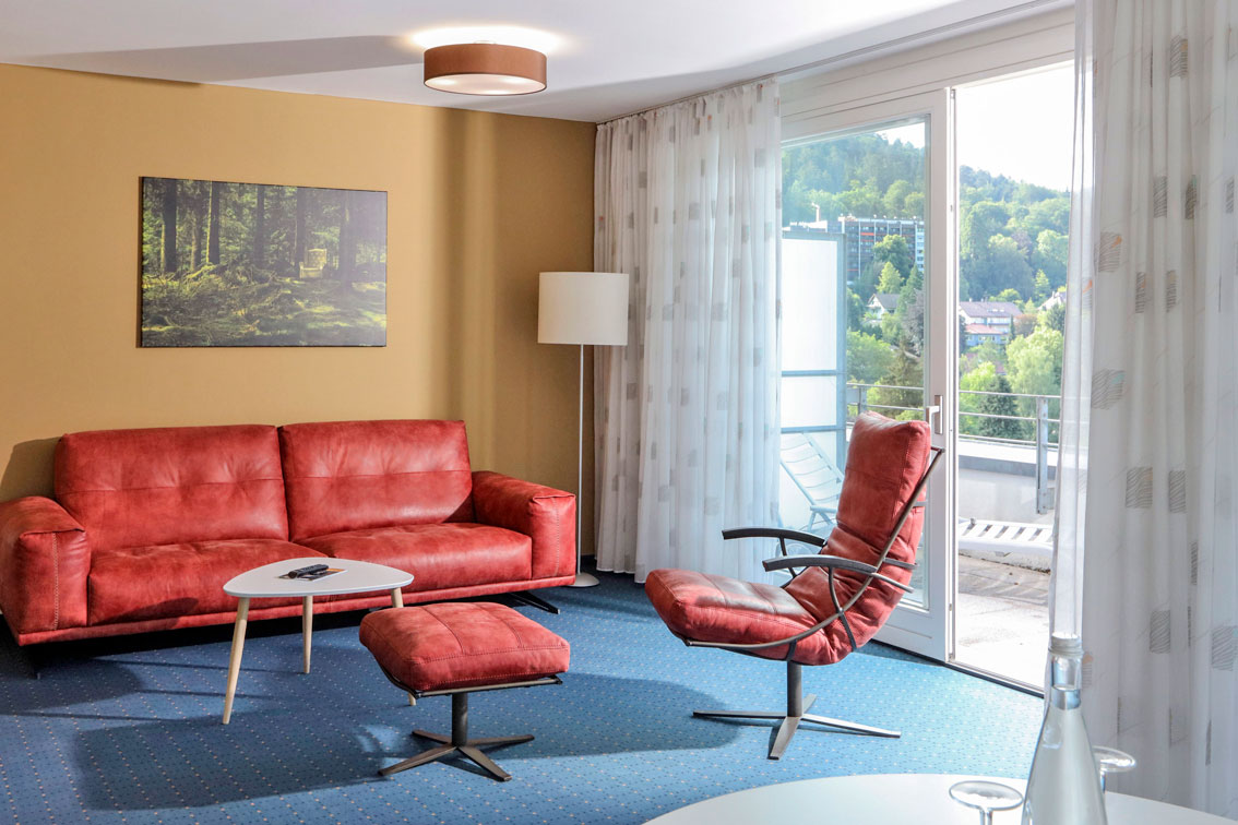 Bright apartment in the Hotel Schwarzwald Panorama with comfortable couch and armchair and balcony
