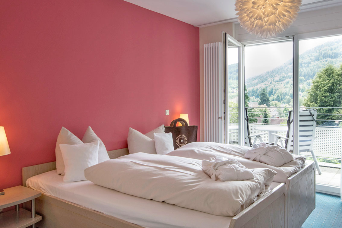 Bedroom with comfortable double bed in an apartment in the Hotel Schwarzwald Panorama with access to the balcony