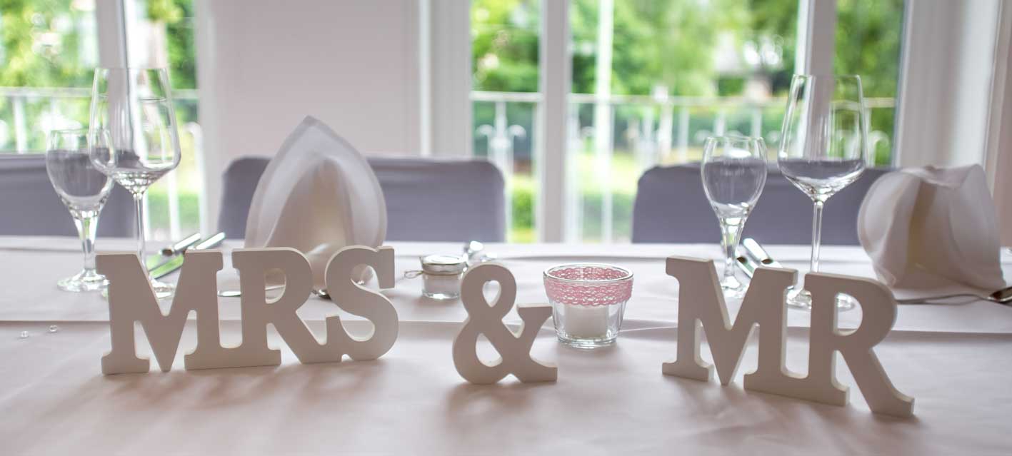 Tischdekoration bei einer Hochzeitsfeier mit großen Buchstabenaufstellern Mrs & Mr
