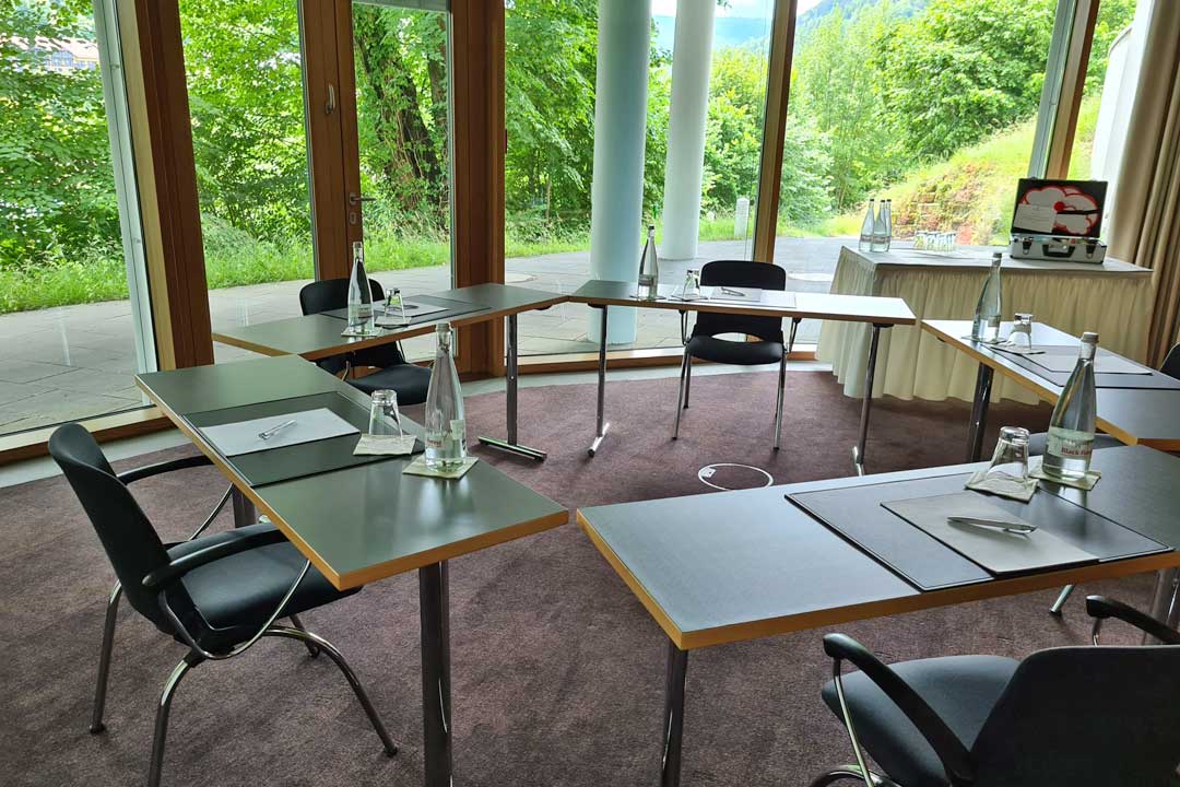 Mehrere Tische stehen im Kreis aufgestellt in einem Tagungsraum im Tagungshotel SCHWARZWALD PANORAMA
