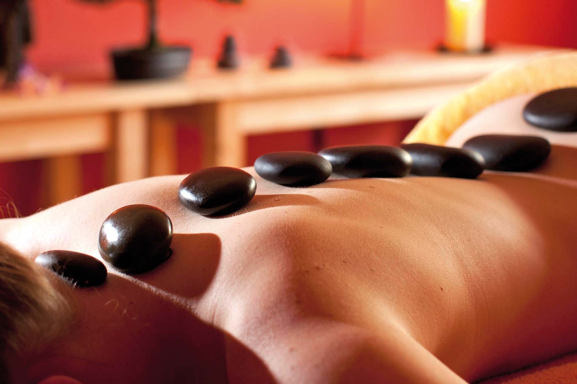 Frau während einer Hot Stone Massage im Selfness Hotel Schwarzwald Panorama